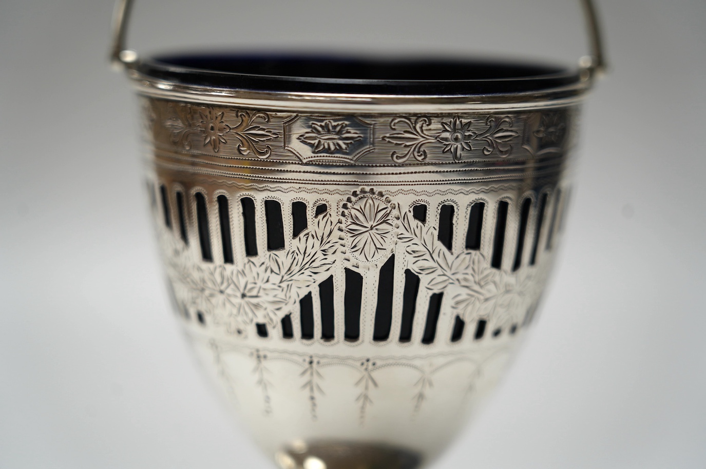 A George III pieced silver pedestal sugar basket, with blue glass liner, John Whittingham?, London, 1790, height 11.5cm. Condition - fair